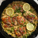 overhead shot of one-pan lemon herbed chicken and rice with lemon slices