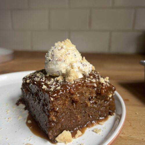 side view of sticky date cake with ice cream on top