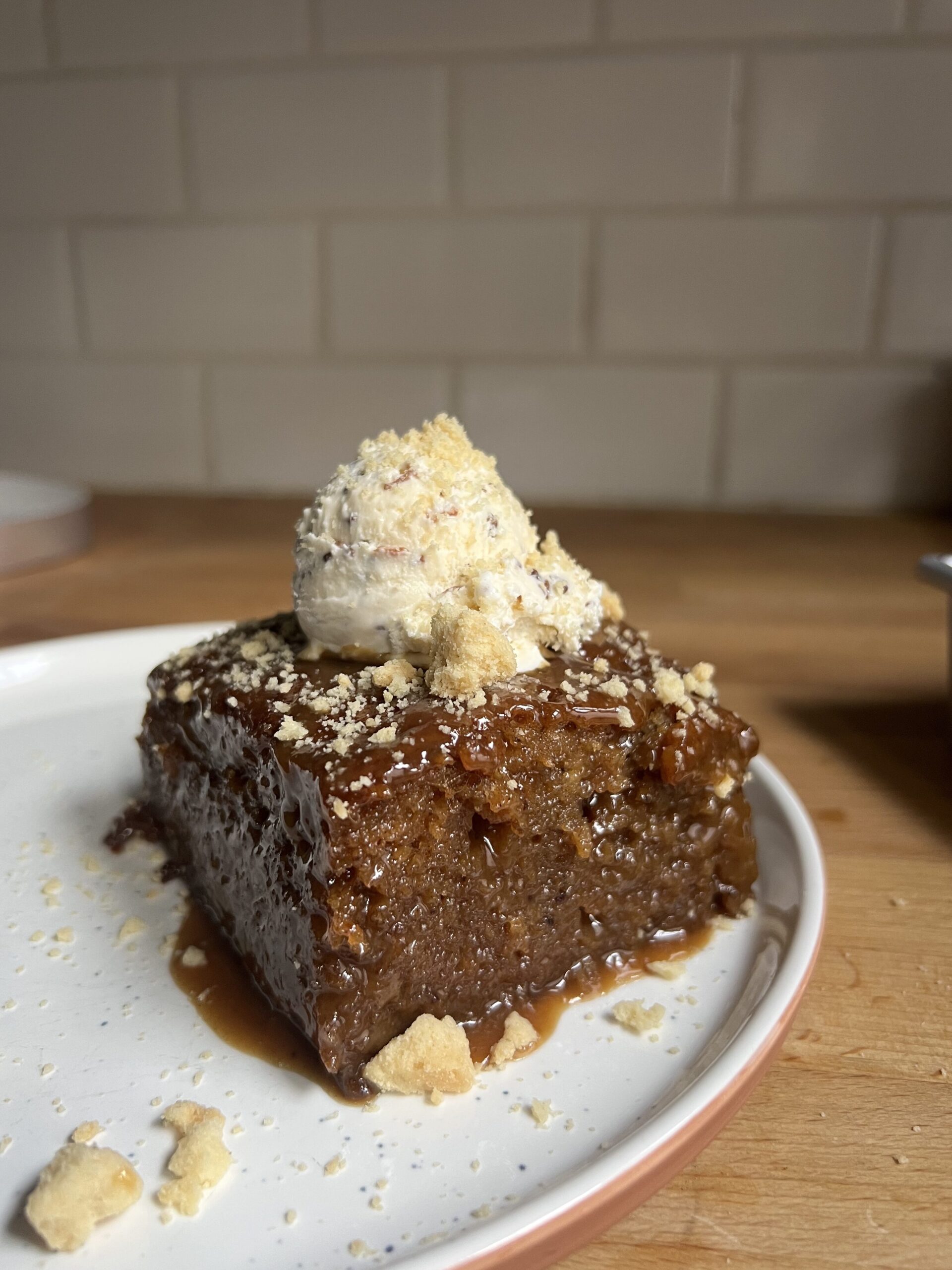 side view of sticky date cake with ice cream on top
