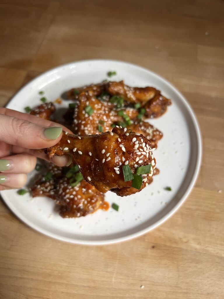 one honey gochujang chicken wing being held 